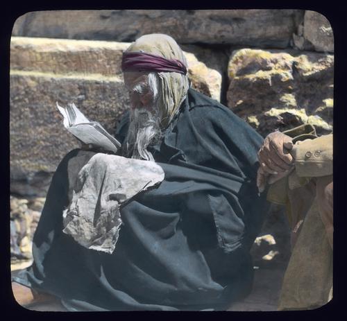 Jewish beggar at the Wailing Wall reading