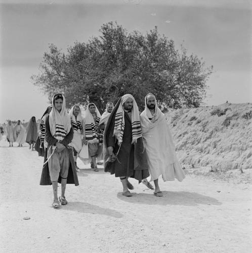 Joodse mannen op Djerba lopen van de Ghriba synagoge naar huis